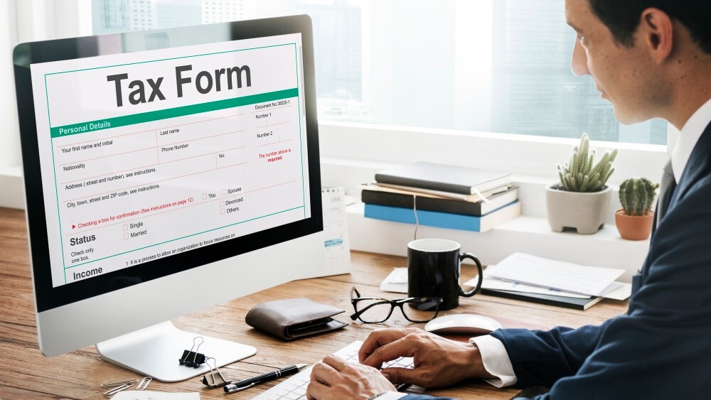 Business owner preparing corporate tax form on computer for CRA tax filing in Canada