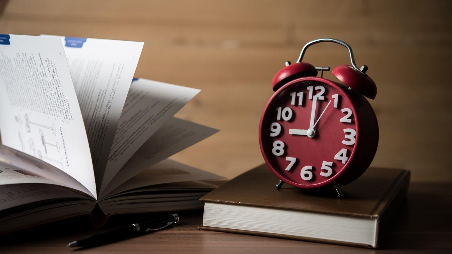 Alarm clock on books representing GST/HST filing and remittance deadlines for Canadian businesses to stay compliant with CRA reporting requirements.