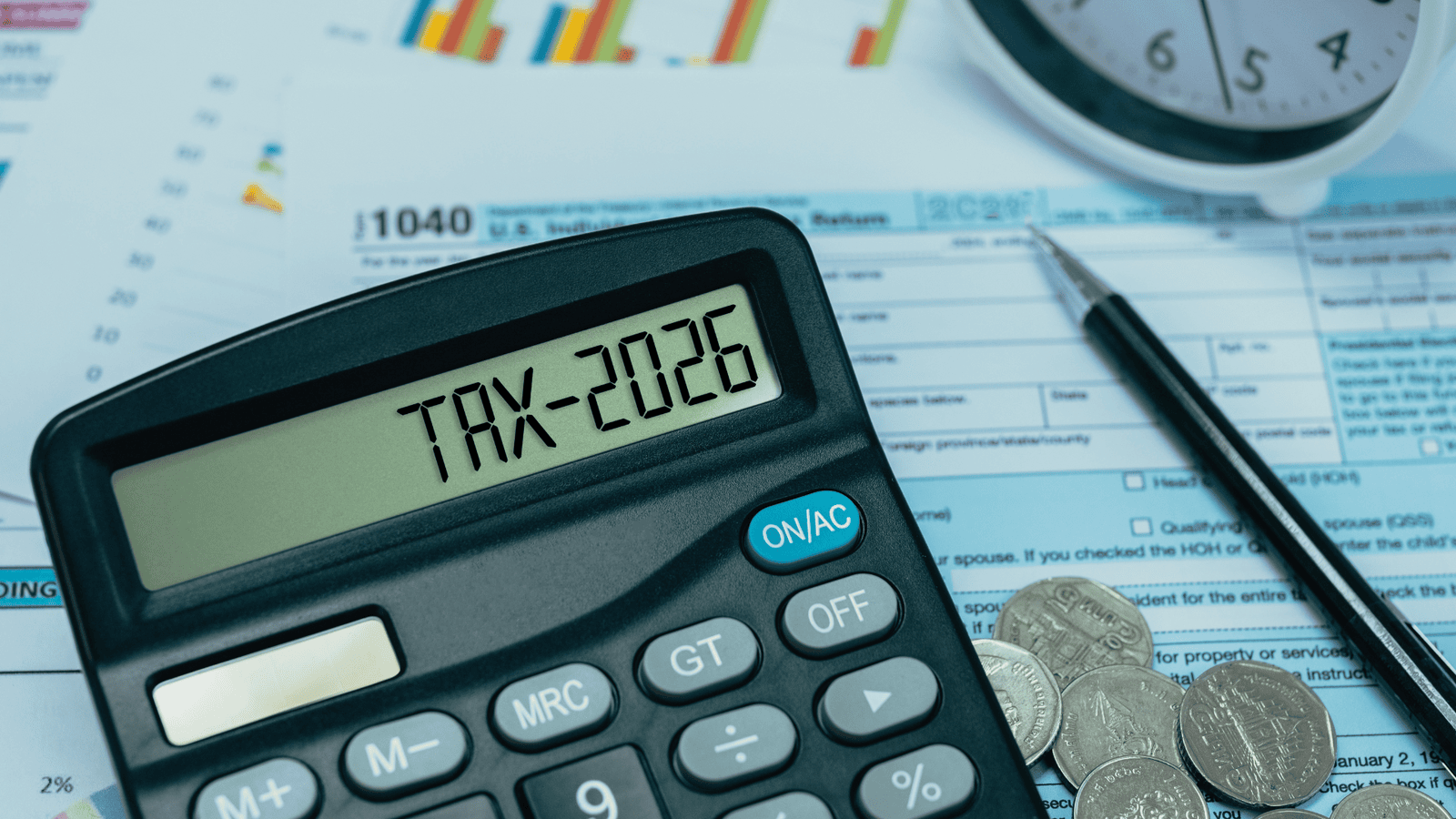 Calculator displaying tax year 2026 on top of tax forms, coins, and documents representing the review of tax deductions, credits, and eligible claims for 2025 Canadian personal tax filing.
