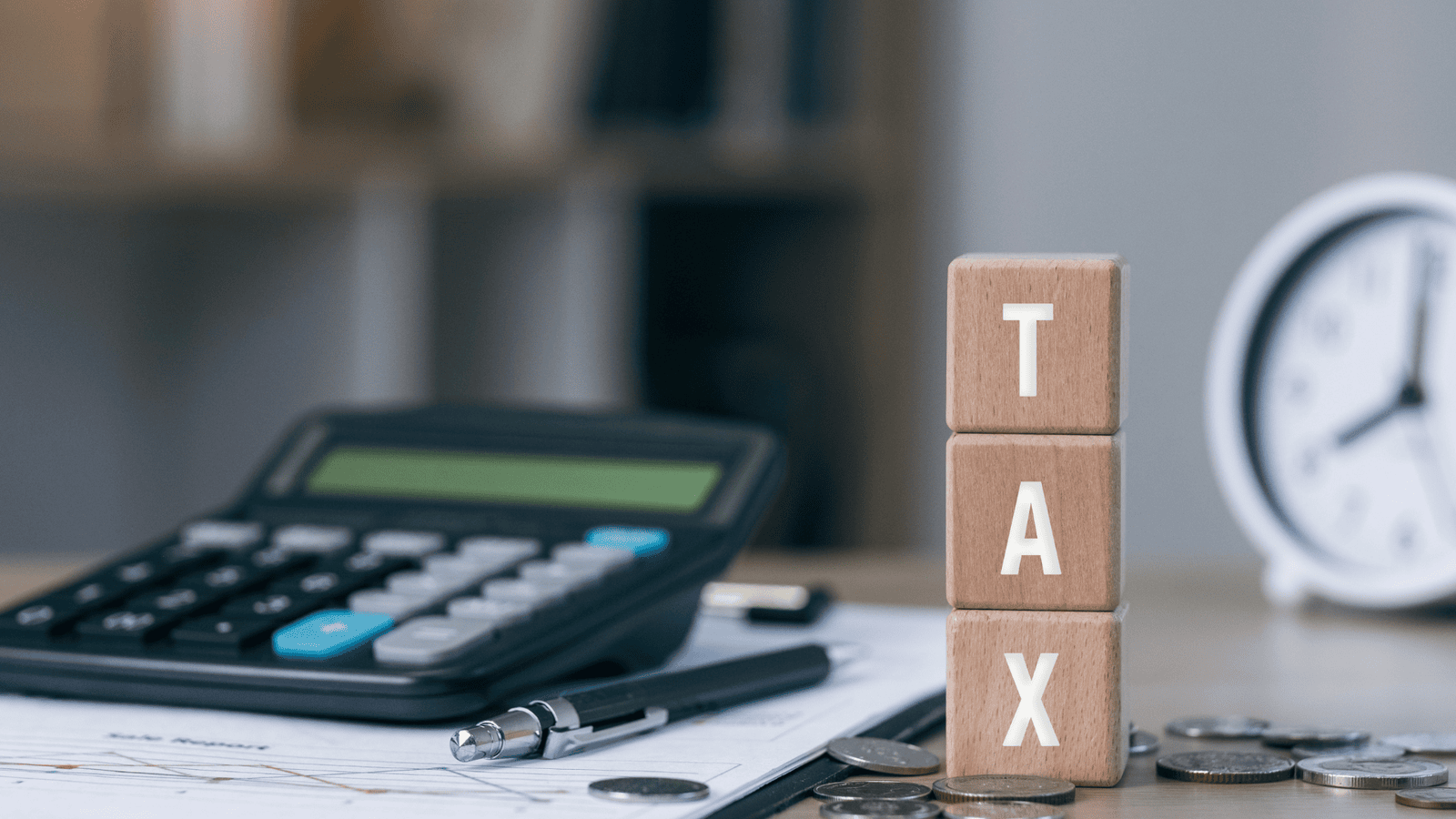 Calculator, clock, coins, and wooden blocks spelling ‘TAX’ representing important 2025 Canadian personal tax filing deadlines, payment due dates, and CRA submission timelines.