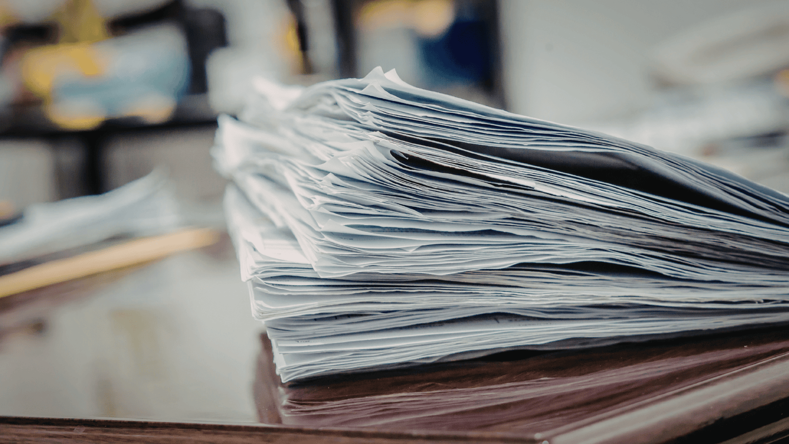 Stack of financial documents and paperwork on a desk representing records required for a CRA audit, including receipts, invoices, bank statements, and supporting tax documents for Canadian small businesses