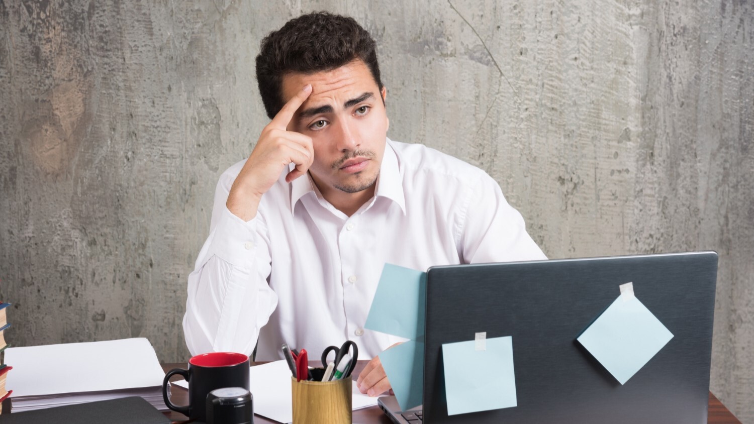 Confused business owner reviewing documents on a laptop representing common GST/HST mistakes and tax compliance challenges for small businesses.