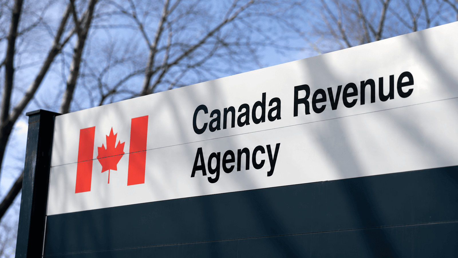 Close-up of a Canada Revenue Agency sign outside a government office, representing the CRA's role in reviewing tax filings, identifying audit triggers, and enforcing compliance for Canadian businesses.
