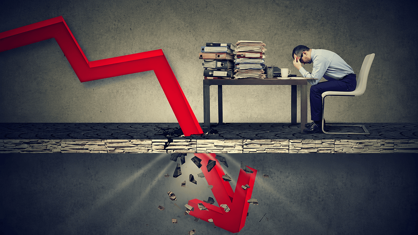 Business owner sitting at a desk piled with financial records as a large downward red arrow breaks through the floor, illustrating how poor record keeping can lead to financial losses, tax issues, and CRA compliance risks for Canadian businesses.
