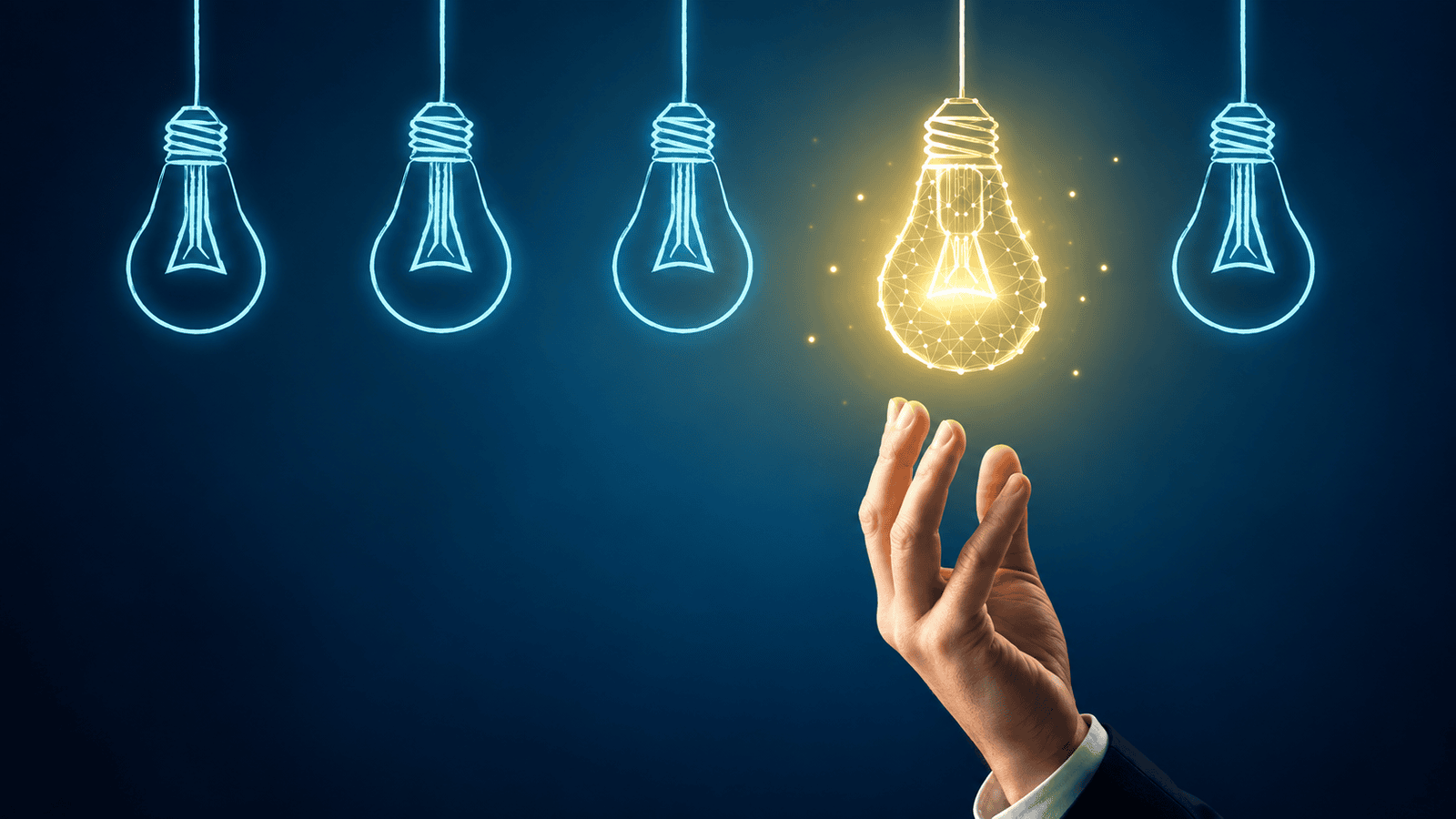 Hand reaching toward a glowing light bulb among several unlit bulbs, representing smarter corporate investment strategies and better tax planning decisions for incorporated business owners in Canada.