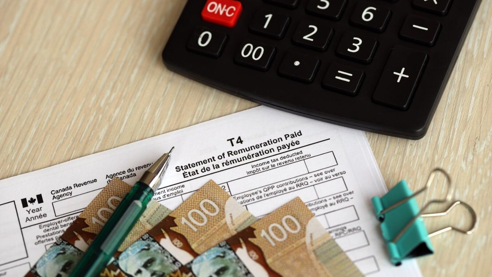 T4 Statement of Remuneration Paid form with Canadian dollar bills and calculator used for payroll tax reporting to the CRA
