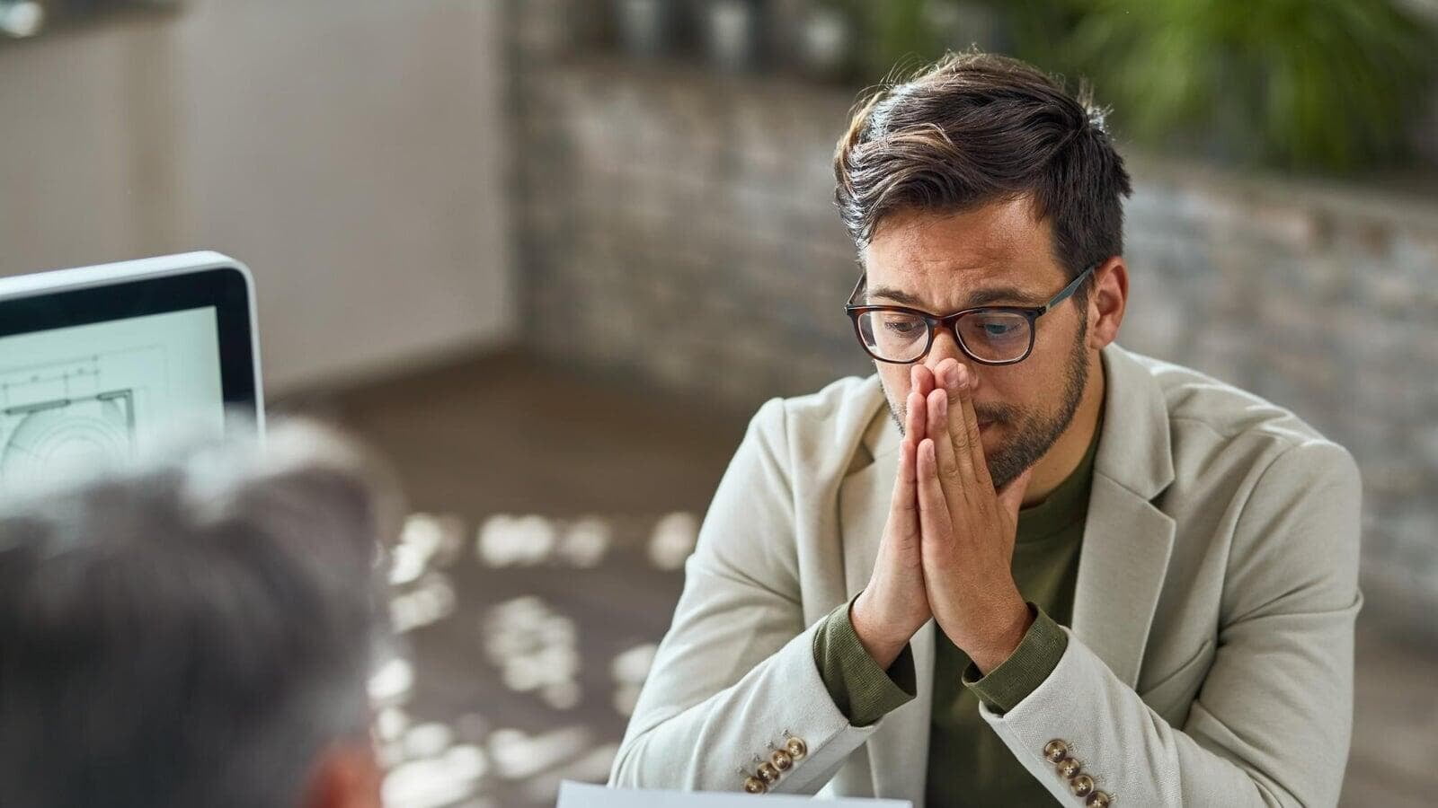 Concerned business owner reviewing a difficult situation during a meeting, representing how poor lead tracking and inconsistent follow-ups can cost contractors thousands in missed sales across London, Ontario.