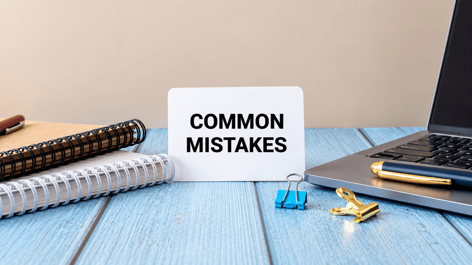 Desk sign reading Common Mistakes beside notebooks and a laptop, representing bookkeeping errors, unsupported expenses, payroll classification issues, and year-end tax problems for small businesses in London, Ontario.