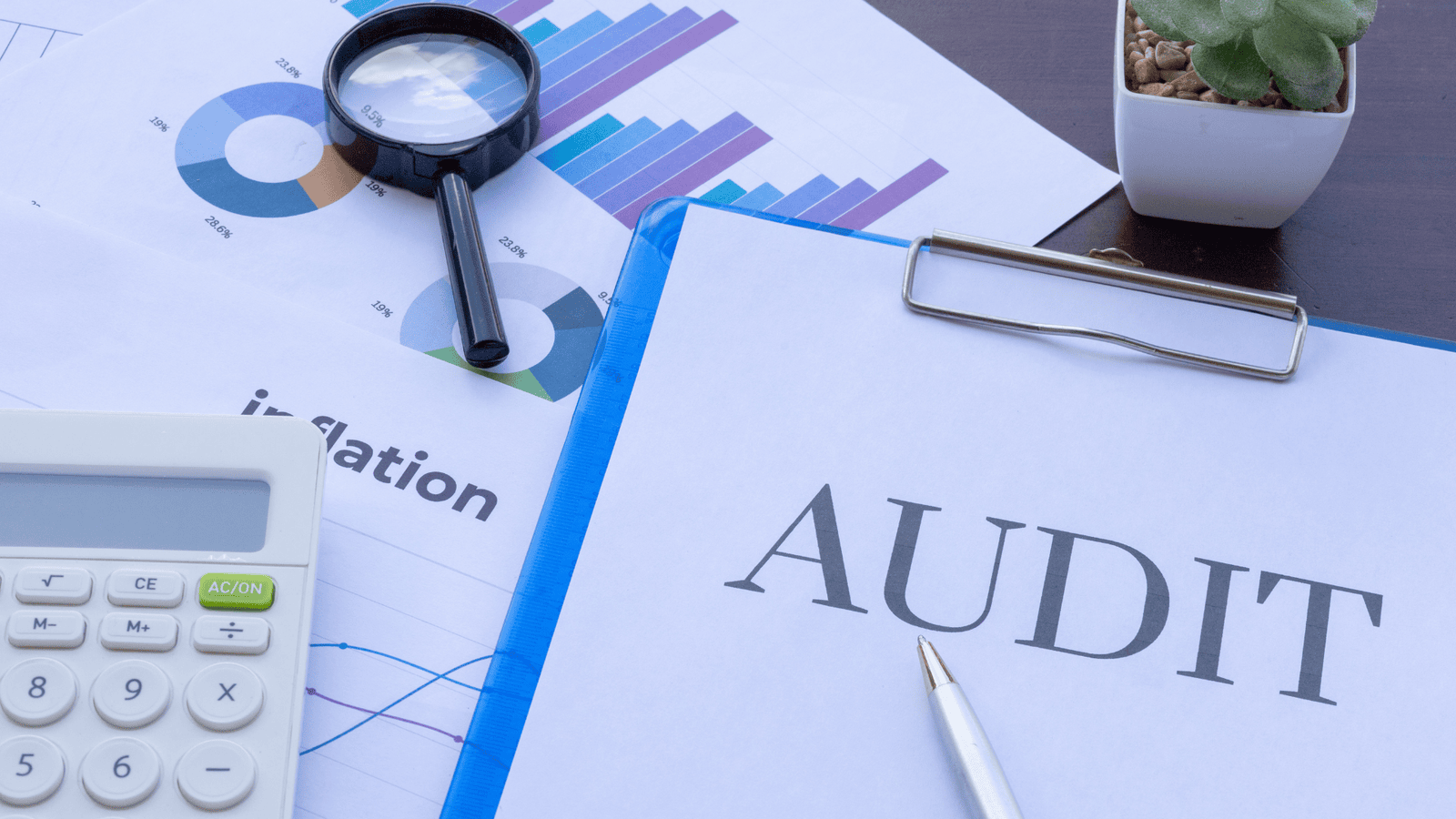 Financial audit concept showing documents labeled ‘Audit’ with charts, calculator, and magnifying glass, representing common CRA audit triggers such as unusual expenses, income discrepancies, and tax reporting issues for Canadian small businesses.