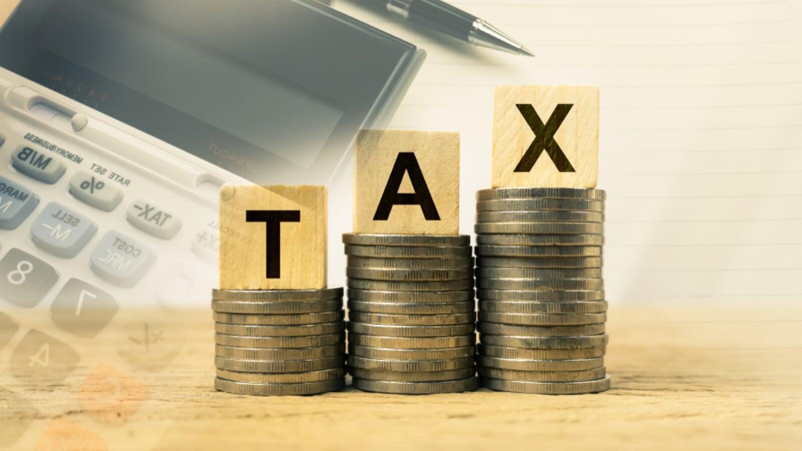 Canadian tax installment concept showing alarm clock labeled ‘TAX’, stacks of coins, and hand placing money, representing CRA tax instalment payments and deadlines for businesses in Canada.