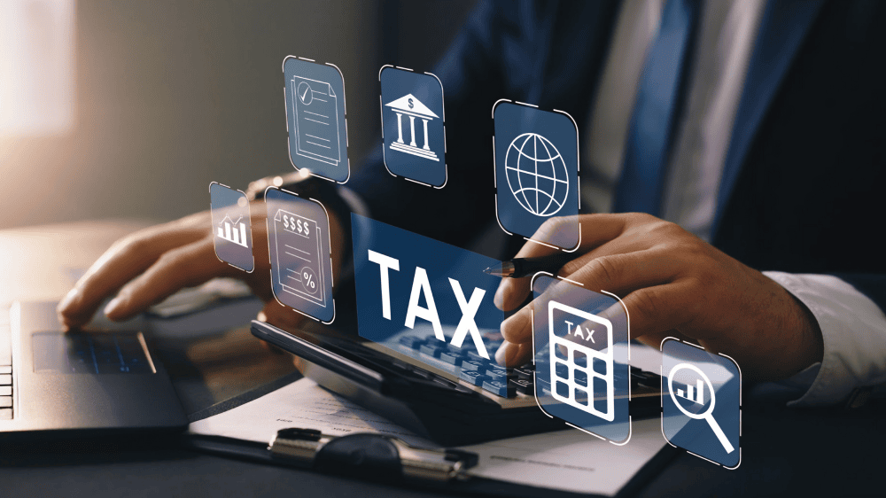 Business professional using a calculator and laptop with digital tax icons, charts, and financial symbols, representing the benefits of proactive tax planning, cash flow management, and CRA compliance for businesses in Ontario, Canada.