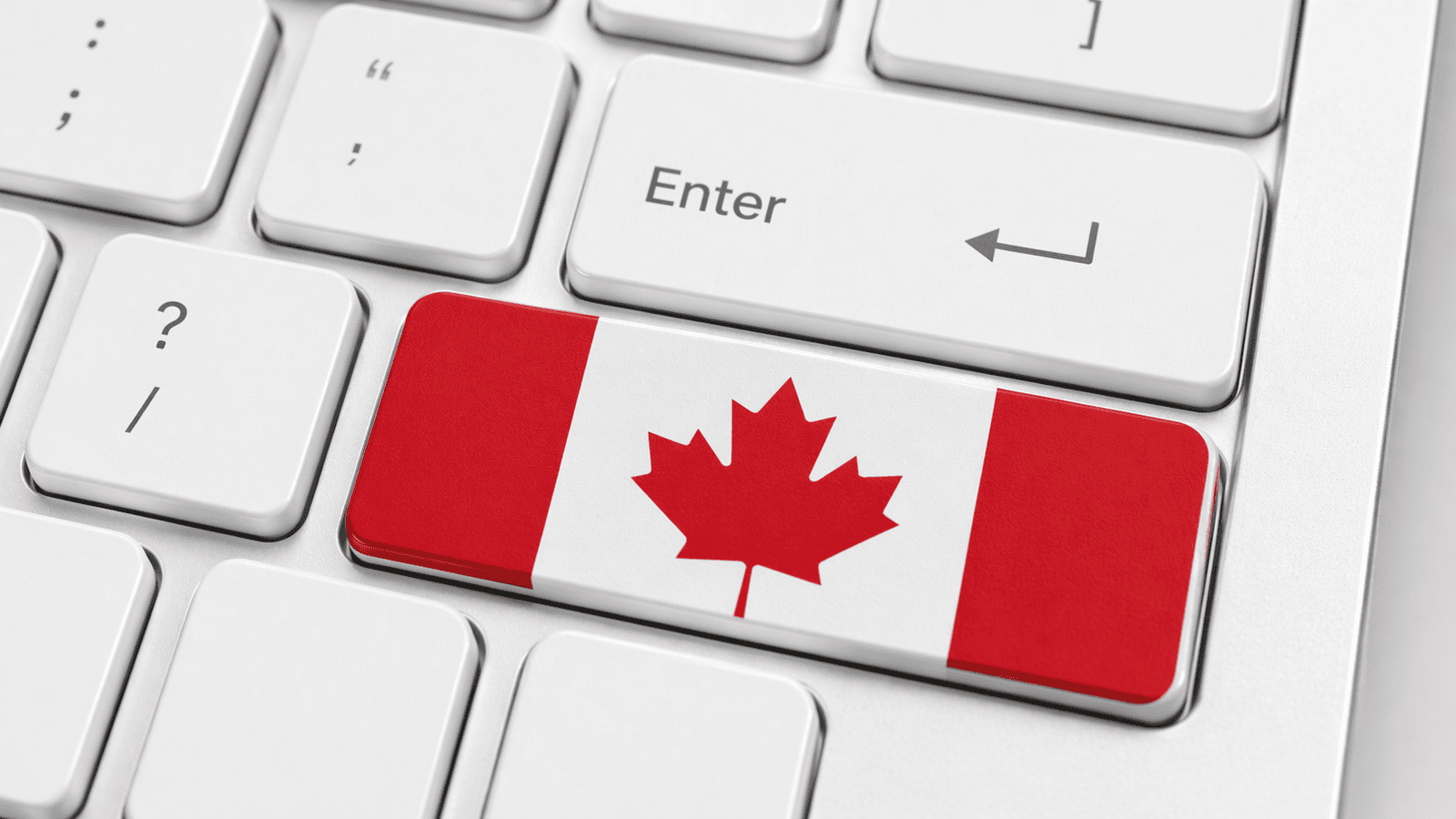 Close-up of a white keyboard with the Enter key beside a Shift key displaying the Canadian flag, representing real actions and responsibilities tied to CRA compliance for small businesses in London, Ontario.