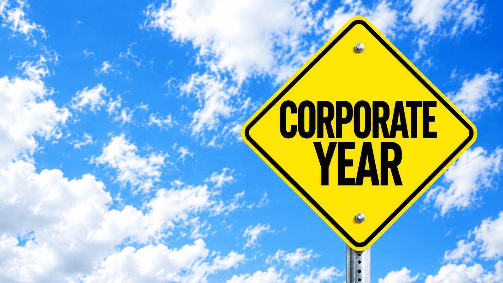 Yellow road-style sign reading ‘Corporate Year’ against a blue sky, representing how a corporation’s fiscal year affects tax reporting, financial planning, and business decisions in Canada.
